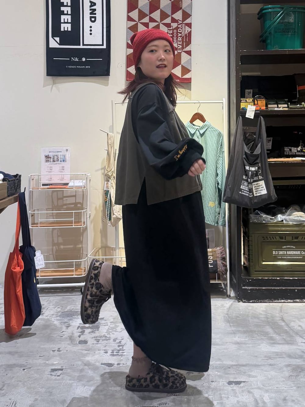 ブラック系のショルダーバッグ、その他のモカシン/デッキシューズ、レッド系のニットキャップ/ビーニーを着用したレディースの秋コーディネートの3枚目の写真