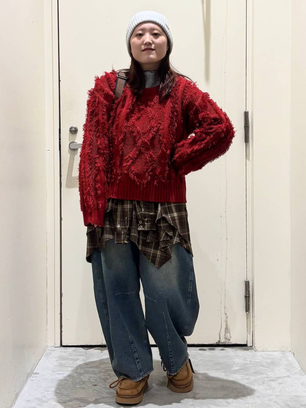 イエロー系のモカシン/デッキシューズ、ブルー系のデニムパンツ、レッド系のニット/セーターを着用したレディースの冬コーディネートの3枚目の写真