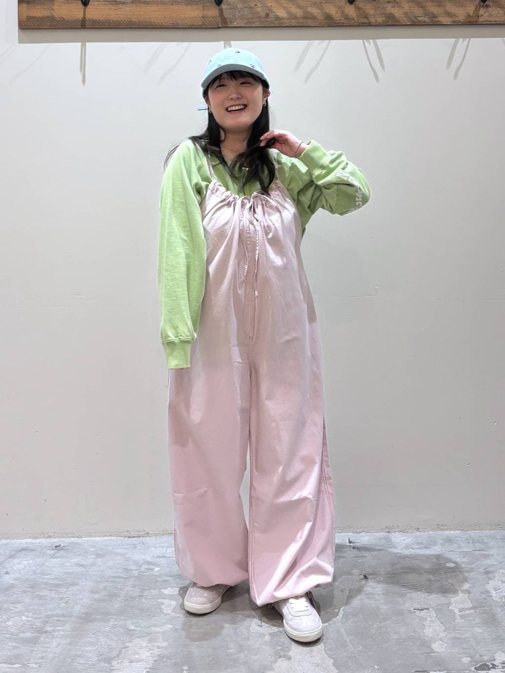 ピンク系のサロペット/オーバーオール、グレー系のスニーカー、グリーン系のスウェットを着用したレディースの春コーディネートの3枚目の写真