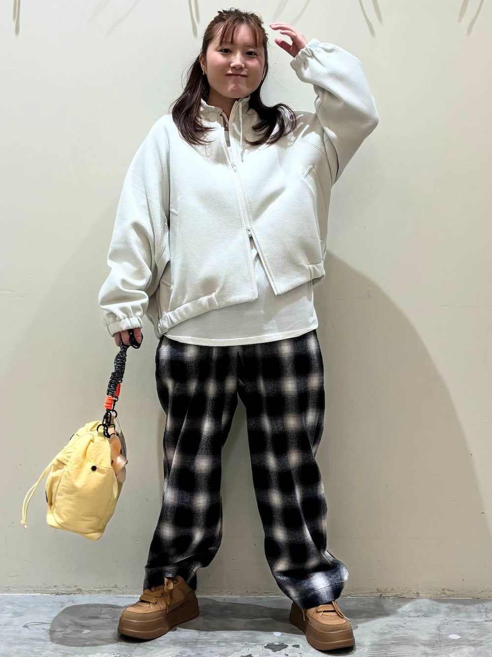 ブラウン系のスニーカー、イエロー系のショルダーバッグを着用したレディースの冬コーディネートの5枚目の写真