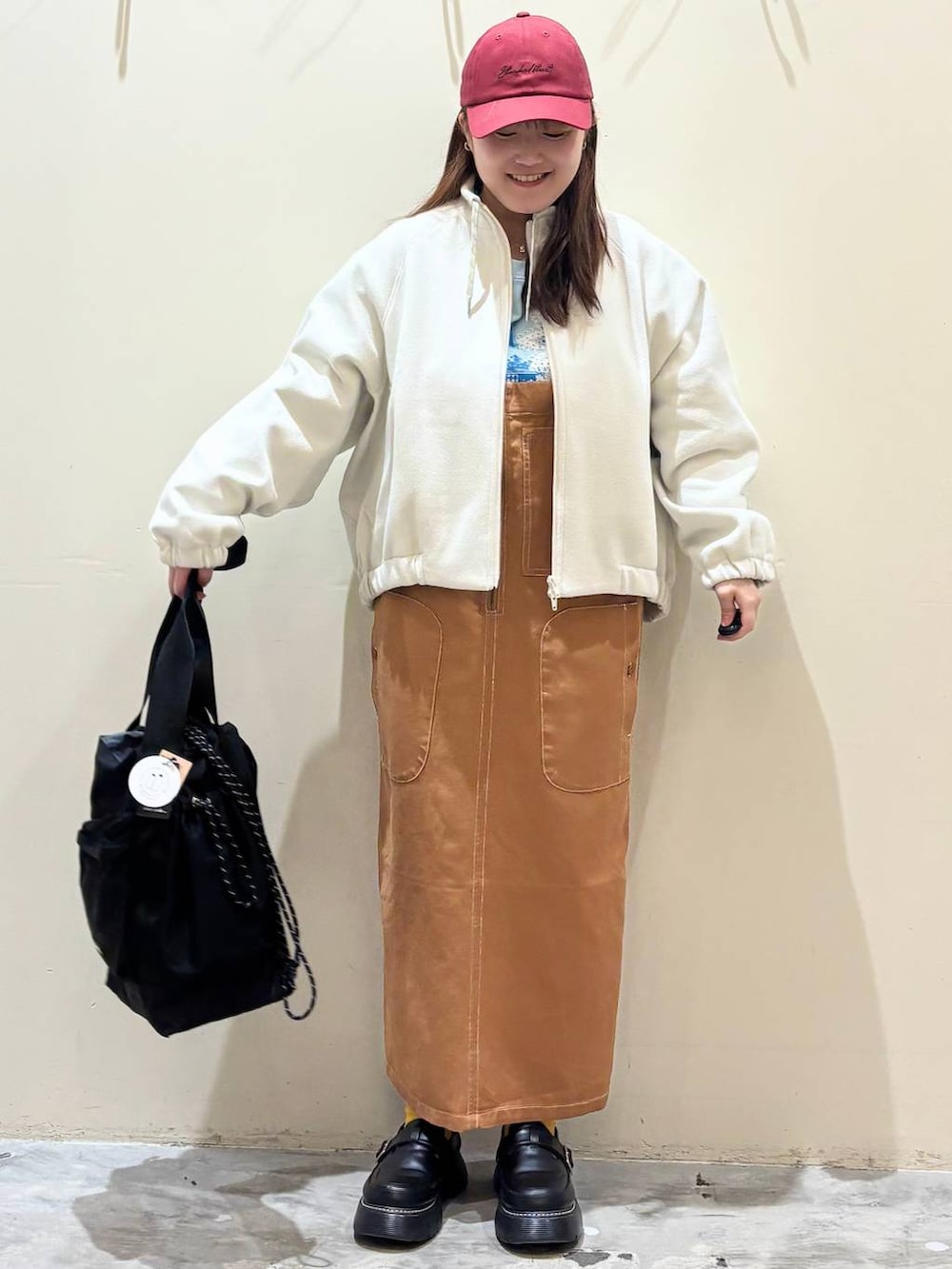 ブラック系のドレスシューズ、ブラウン系のジャンパースカート、ベージュ系のブルゾンを着用したレディースの冬コーディネートの4枚目の写真