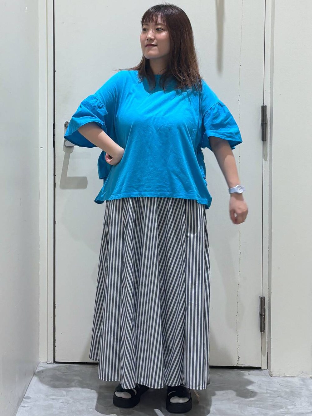 ブラック系のサンダル、ブルー系のスカート、ブルー系のTシャツ/カットソーを着用したレディースの夏コーディネートの3枚目の写真