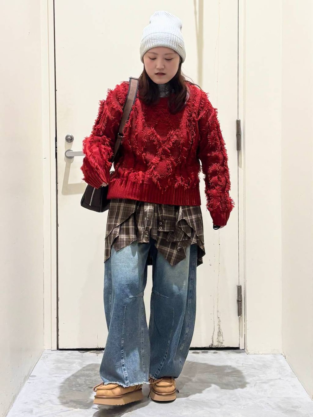 イエロー系のモカシン/デッキシューズ、ブルー系のデニムパンツ、レッド系のニット/セーターを着用したレディースの冬コーディネートの4枚目の写真