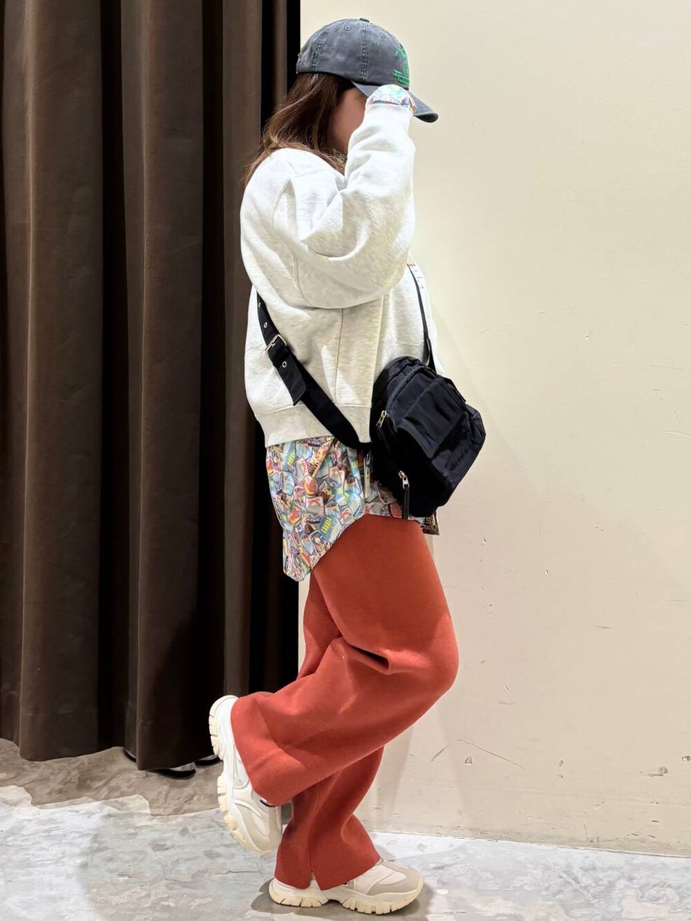 オレンジ系のその他パンツ、ブラック系のショルダーバッグ、ベージュ系のその他トップスを着用したレディースの冬コーディネートの5枚目の写真