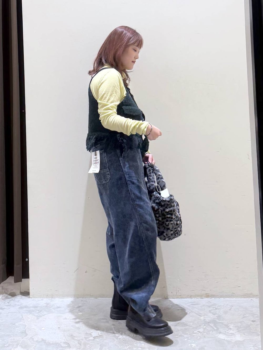 グリーン系のベスト、その他のトートバッグ、イエロー系のTシャツ/カットソーを着用したレディースの秋コーディネートの4枚目の写真