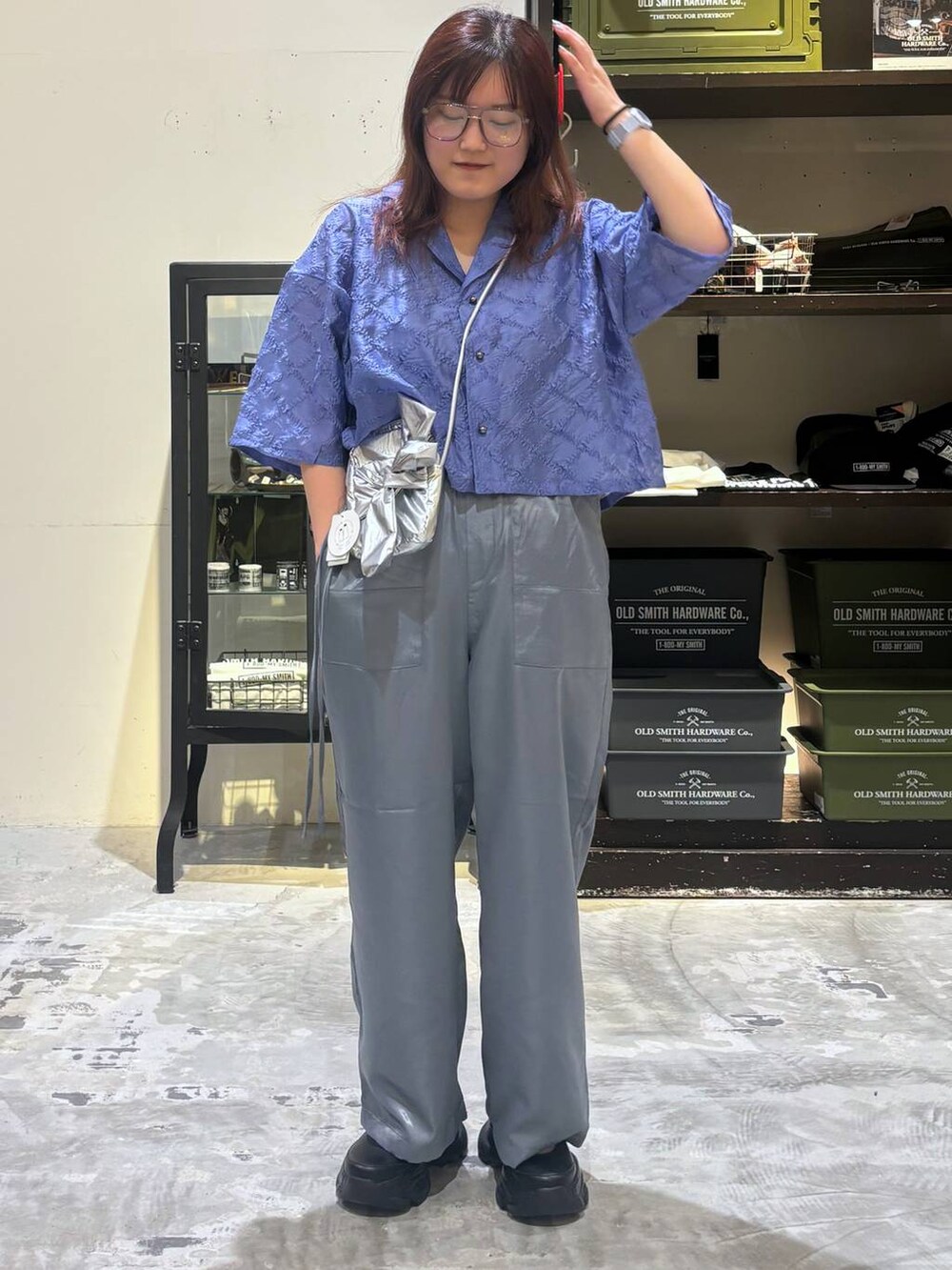 ブラック系のスニーカー、グレー系のショルダーバッグ、ブルー系のシャツ/ブラウスを着用したレディースの夏コーディネートの5枚目の写真