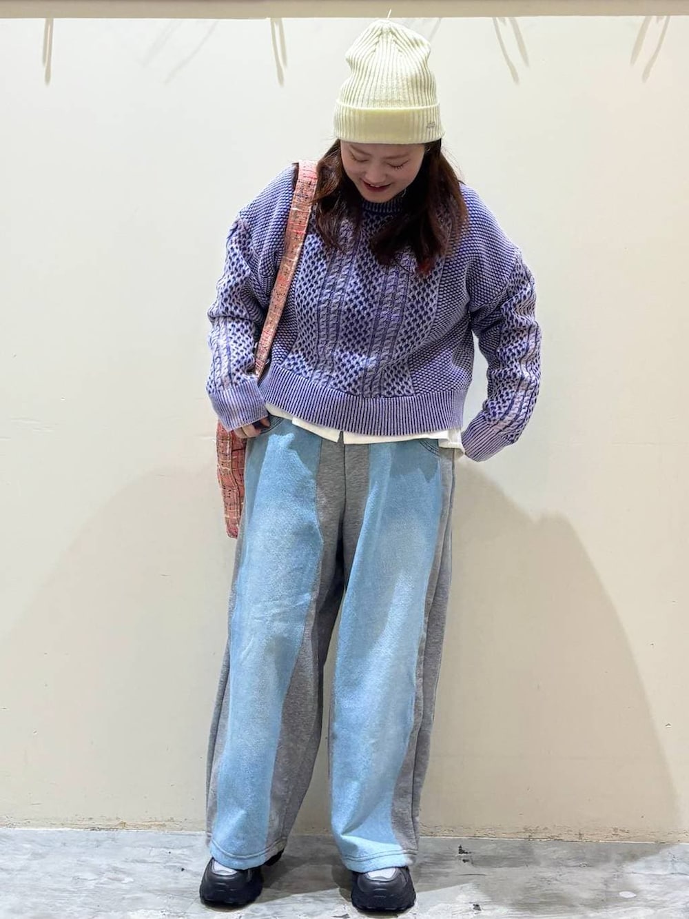 グレー系のデニムパンツ、グレー系のスニーカー、ピンク系のトートバッグを着用したレディースの冬コーディネートの3枚目の写真