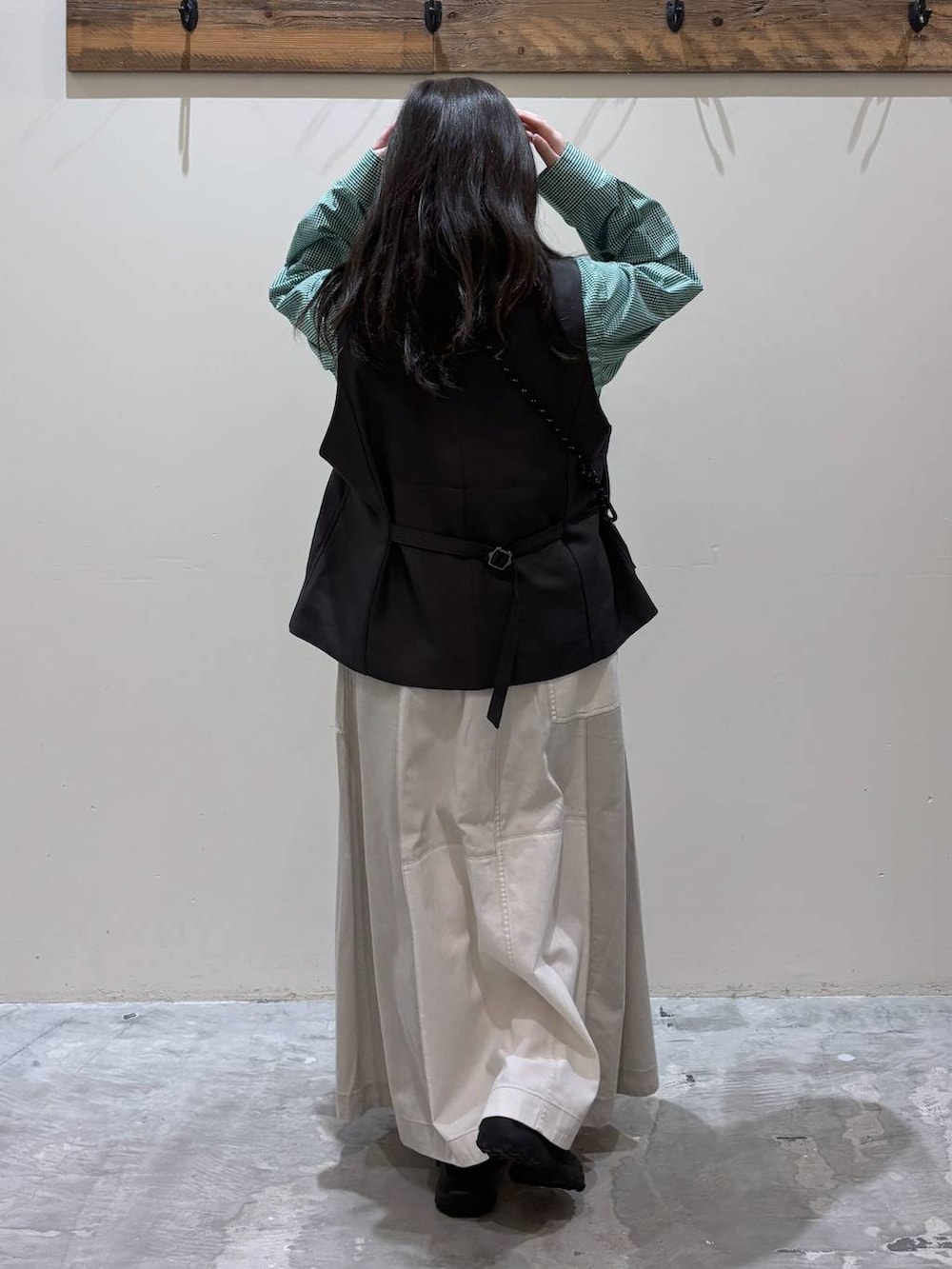 グリーン系のショルダーバッグ、ブラック系のベスト、ブラック系のバレエシューズを着用したレディースの春コーディネートの5枚目の写真