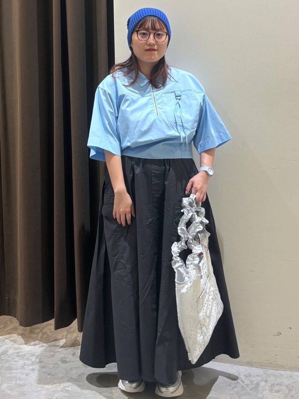 シルバー系のトートバッグ、シルバー系のスニーカー、グレー系のスカートを着用したレディースの夏コーディネートの3枚目の写真