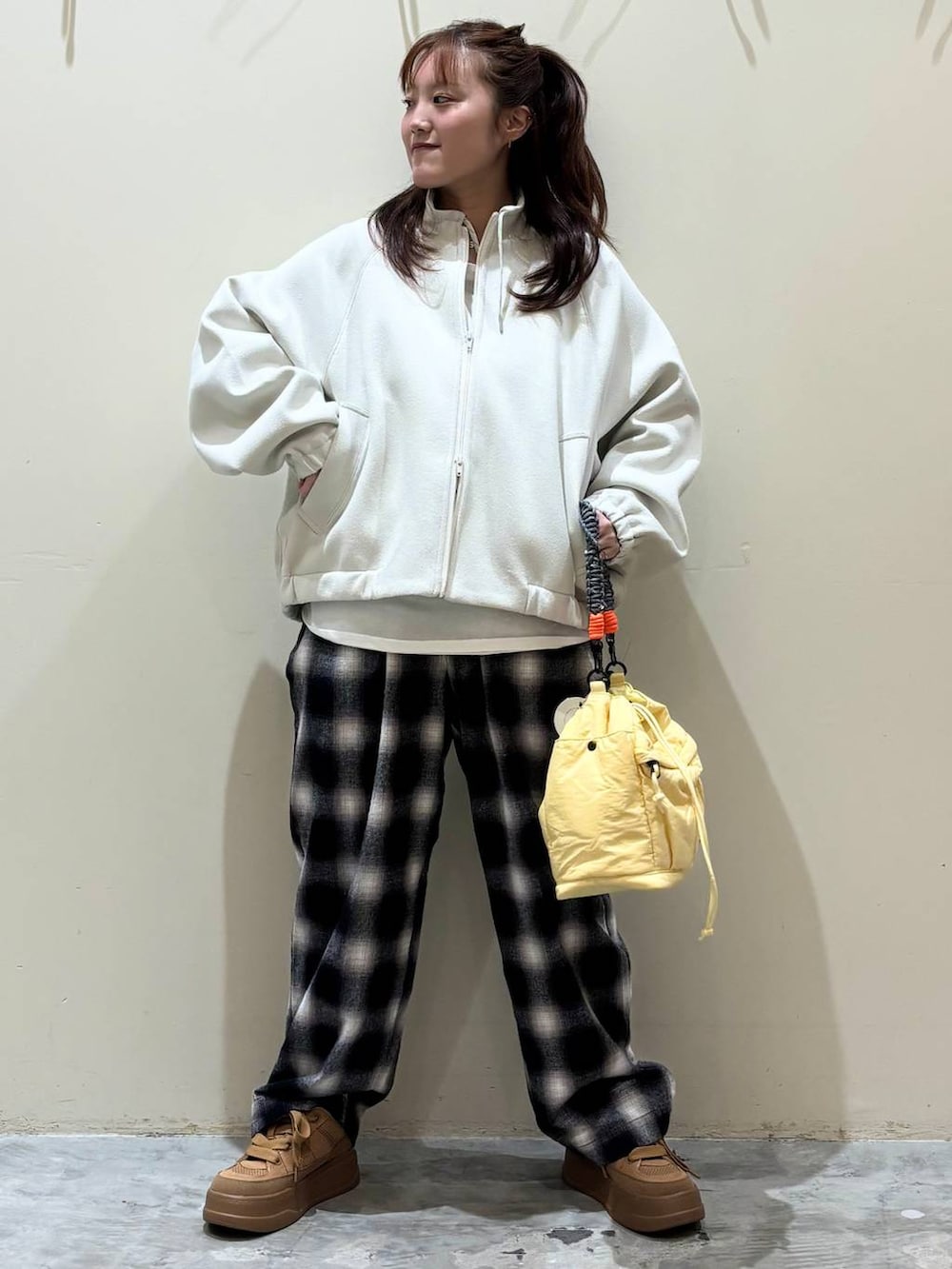 ブラウン系のスニーカー、イエロー系のショルダーバッグを着用したレディースの冬コーディネートの3枚目の写真