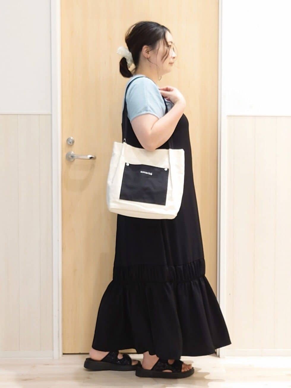 ブラック系のワンピース、ブルー系のTシャツ/カットソー、ブラック系のサンダルを着用したレディースの夏コーディネートの2枚目の写真