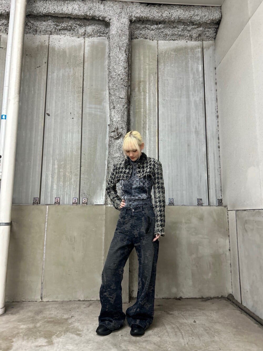 ブラック系のブーツ、ブラック系のデニムパンツ、ブルー系のタンクトップを着用したレディースの冬コーディネートの2枚目の写真