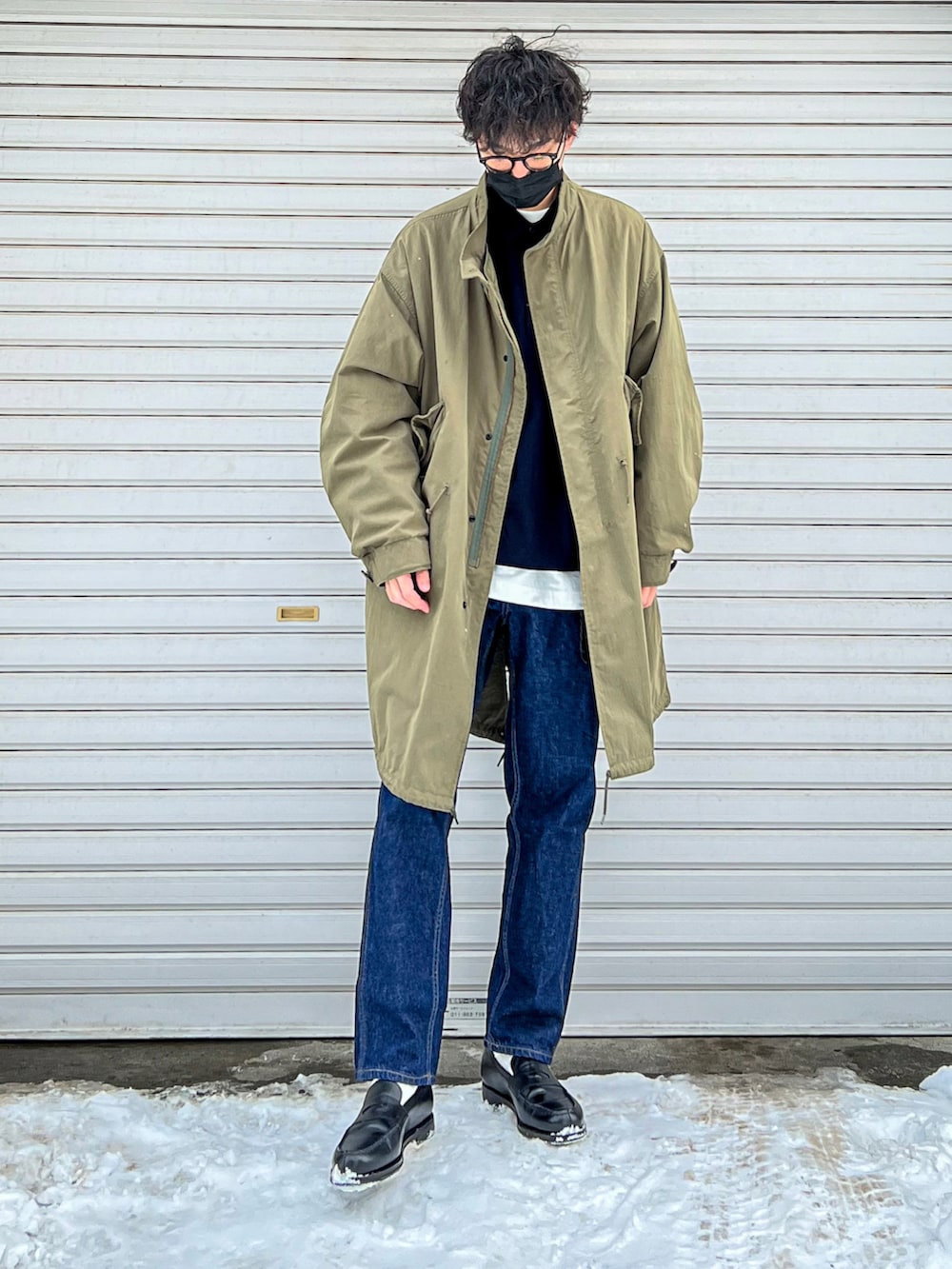 ブルー系のスウェット、グリーン系のモッズコート、ブルー系のデニムパンツを着用したメンズの春コーディネートの3枚目の写真