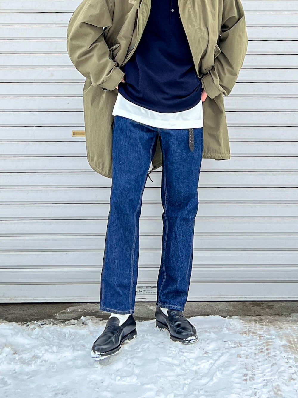 ブルー系のスウェット、グリーン系のモッズコート、ブルー系のデニムパンツを着用したメンズの春コーディネートの4枚目の写真