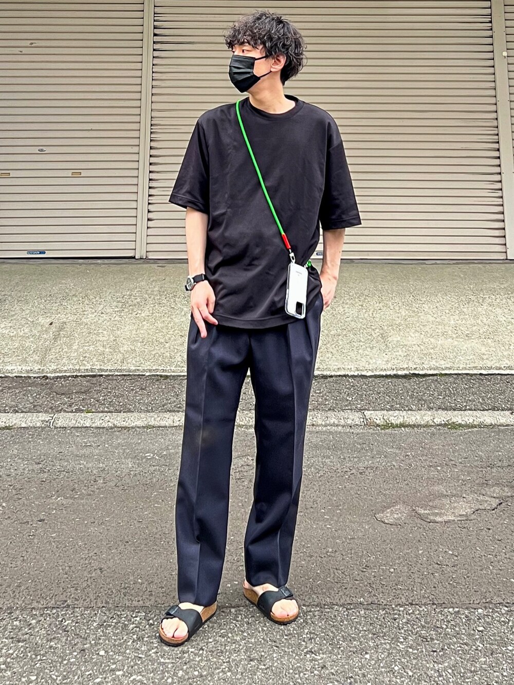ブラック系のTシャツ/カットソー、ブルー系のパンツ、ブラック系のサンダルを着用したメンズの夏コーディネートの2枚目の写真