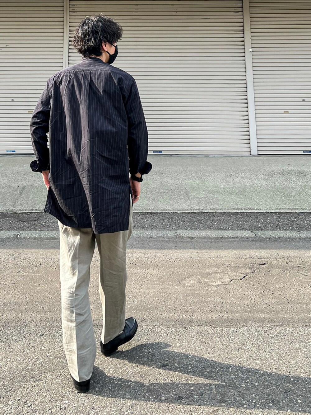 ブラック系のシャツ/ブラウス、グレー系のパンツ、ブラック系のローファーを着用したメンズの夏コーディネートの3枚目の写真