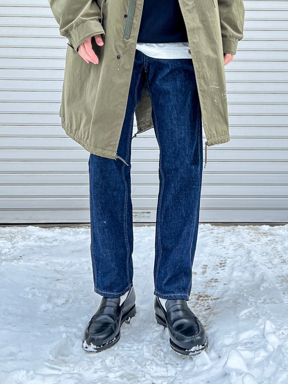 ブルー系のスウェット、グリーン系のモッズコート、ブルー系のデニムパンツを着用したメンズの春コーディネートの2枚目の写真