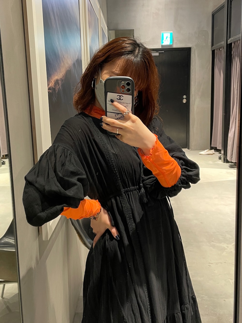 オレンジ系のTシャツ/カットソー、ブラック系のワンピース、ブラック系のトートバッグを着用したレディースの春コーディネートの3枚目の写真