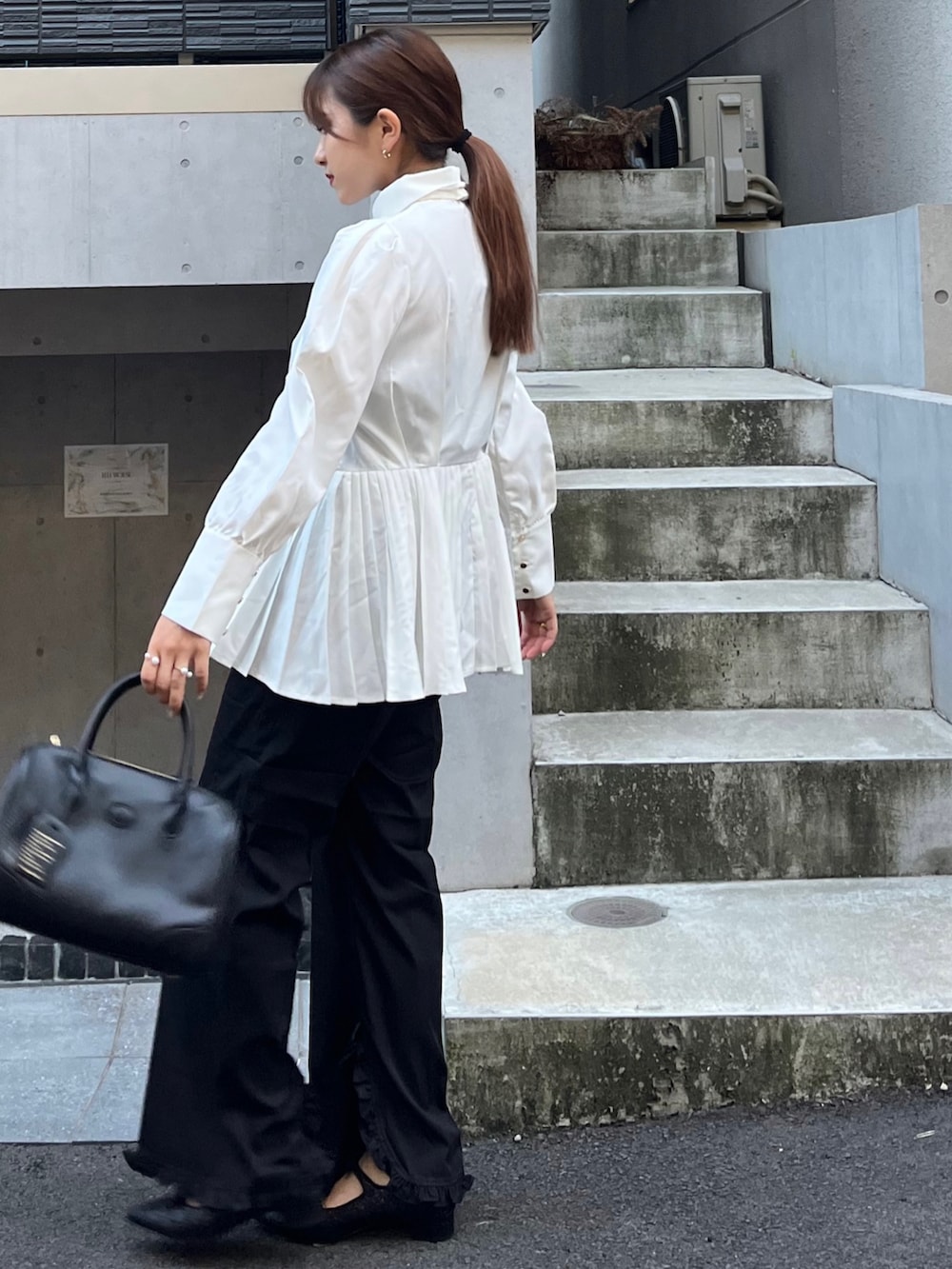 ホワイト系のシャツ/ブラウス、ブラック系のその他パンツ、ブラック系のボストンバッグを着用したレディースの秋コーディネートの2枚目の写真