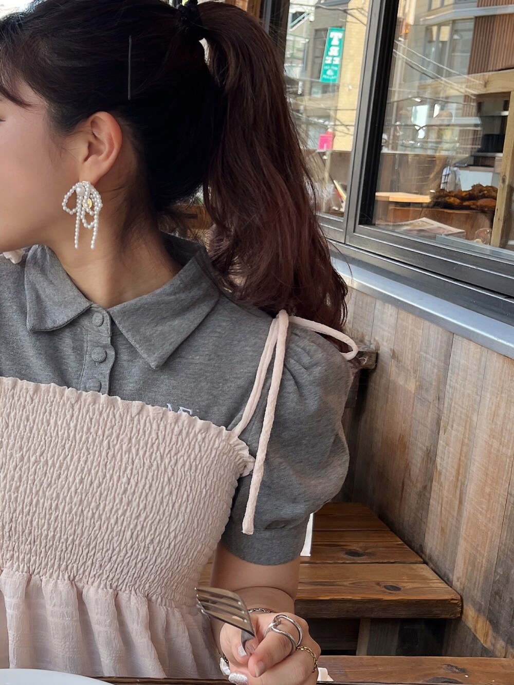 ホワイト系のバッグ、ピンク系のワンピース/ドレス、グレー系のポロシャツを着用したレディースの春コーディネートの2枚目の写真