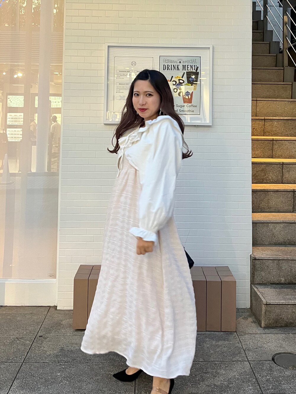 ブラック系のショルダーバッグ、ピンク系のワンピース/ドレス、ホワイト系のカーディガン/ボレロを着用したレディースの春コーディネートの3枚目の写真