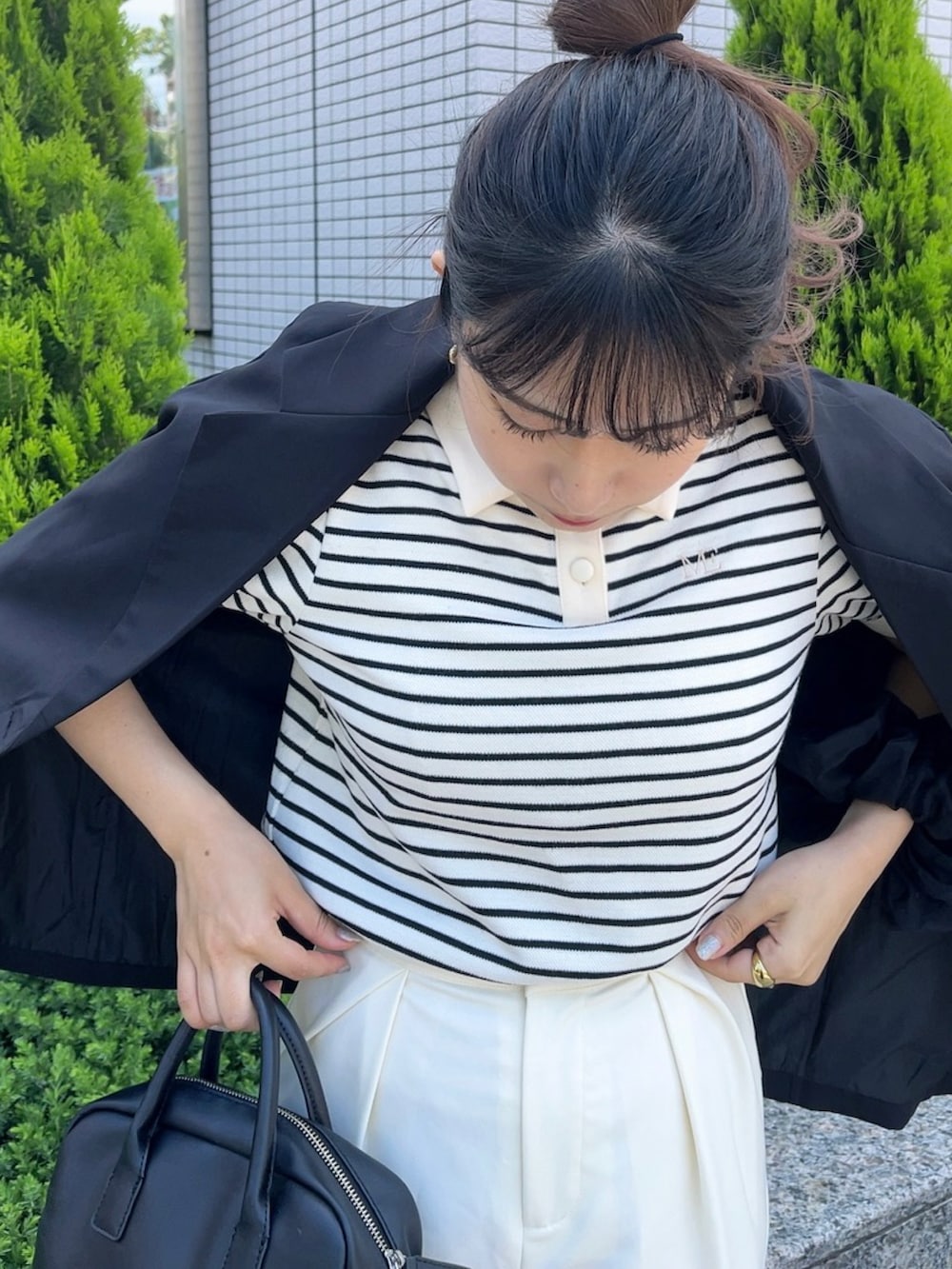 ブラック系のショルダーバッグ、ホワイト系のポロシャツ、ベージュ系のパンプスを着用したレディースの夏コーディネートの3枚目の写真