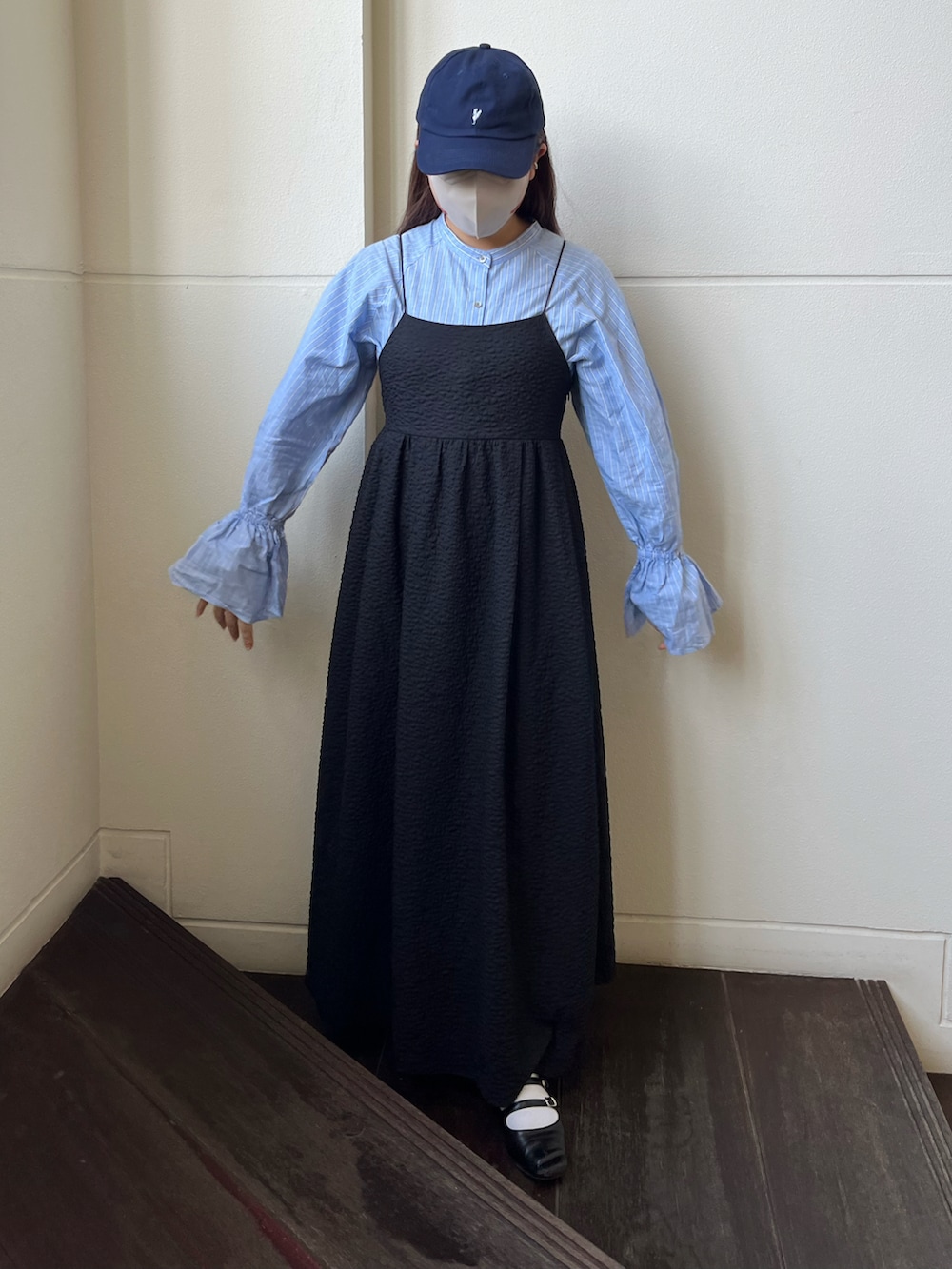 ブルー系のシャツ/ブラウス、ブラック系のワンピース、ブルー系のキャップを着用したレディースの冬コーディネートの2枚目の写真