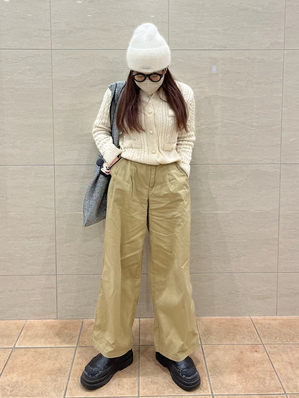 ホワイト系のカーディガン/ボレロ、ベージュ系のチノパンツ、シルバー系のトートバッグを着用したレディースの冬コーディネートの2枚目の写真