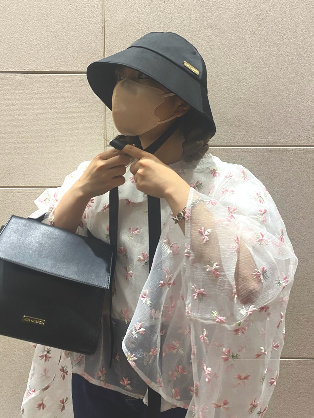ピンク系のシャツ/ブラウス、ブルー系のデニムパンツ、ブラック系のパンプスを着用したレディースの夏コーディネートの2枚目の写真