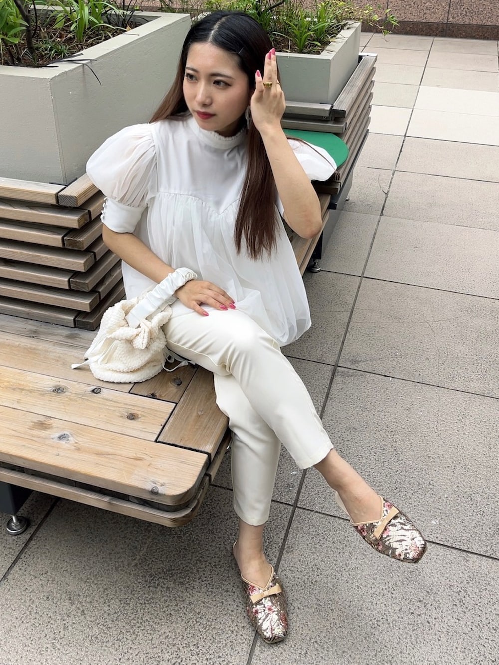 ホワイト系のシャツ/ブラウス、ホワイト系のスラックス、ホワイト系のハンドバッグを着用したレディースの夏コーディネートの2枚目の写真