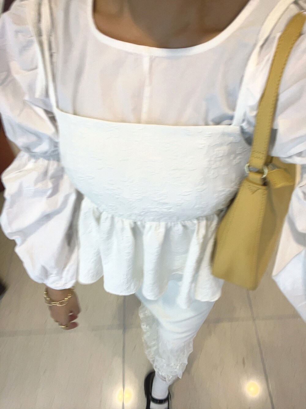 イエロー系のハンドバッグ、ホワイト系のキャミソール、ホワイト系のスカートを着用したレディースの春コーディネートの4枚目の写真