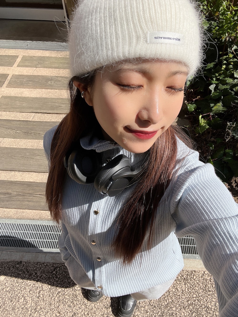 グレー系のスウェットパンツ、ブルー系のカーディガン/ボレロ、ホワイト系のニットキャップ/ビーニーを着用したレディースの春コーディネートの3枚目の写真