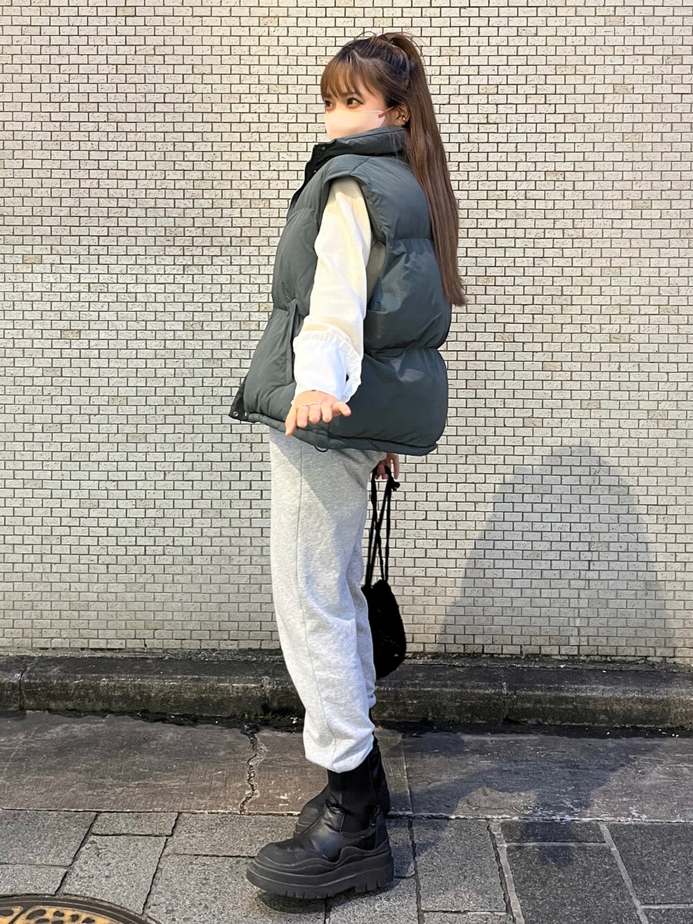 ホワイト系のニット/セーター、グレー系のスウェットパンツ、ブラック系のハンドバッグを着用したレディースの秋コーディネートの2枚目の写真