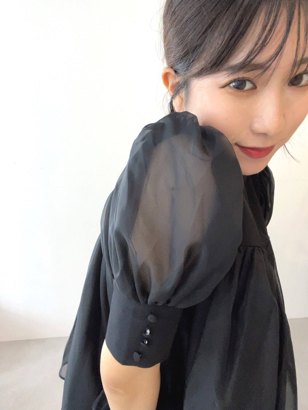 ブラック系のトップス、ホワイト系のスラックスを着用したレディースの夏コーディネートの3枚目の写真