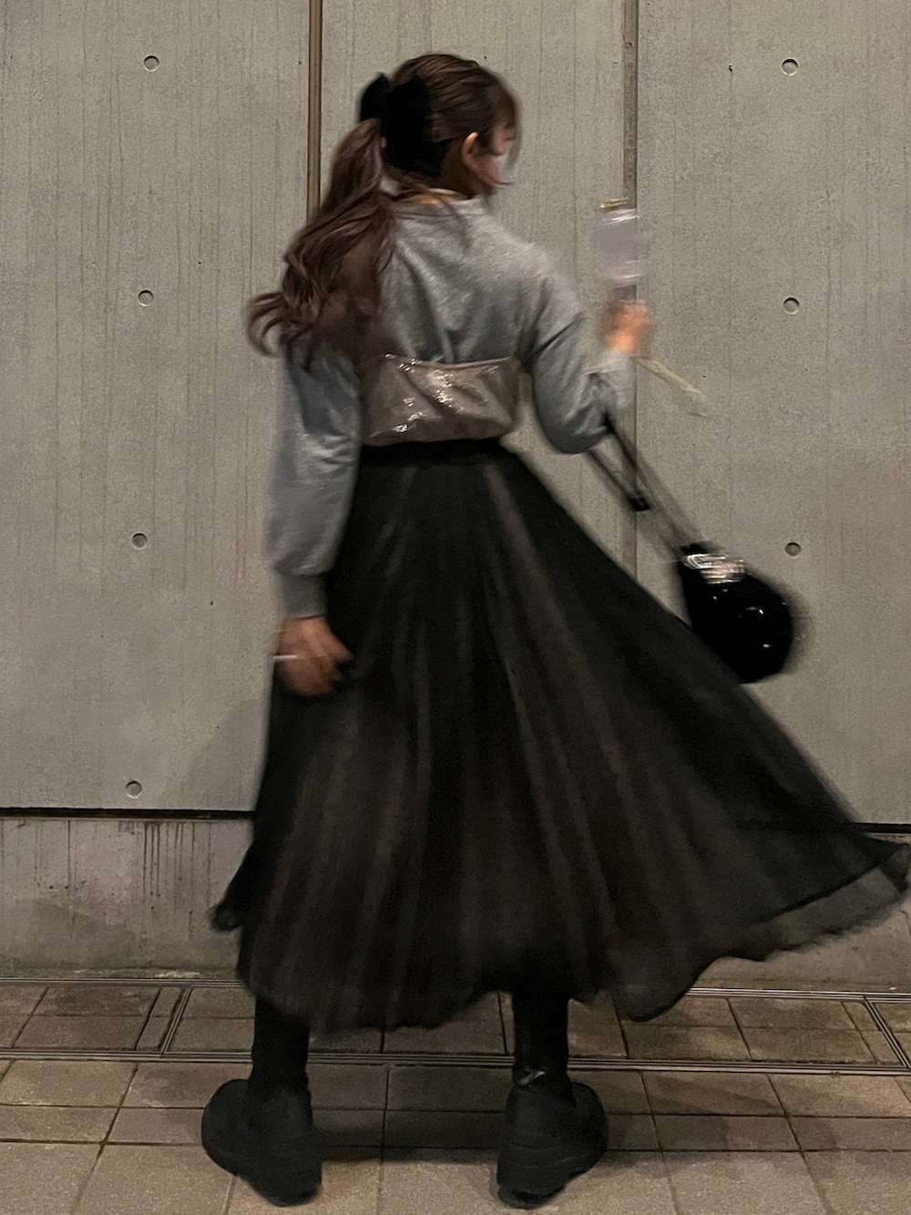 ブラック系のスカート、ブラック系のハンドバッグ、ピンク系のワンピース/ドレスを着用したレディースの冬コーディネートの2枚目の写真