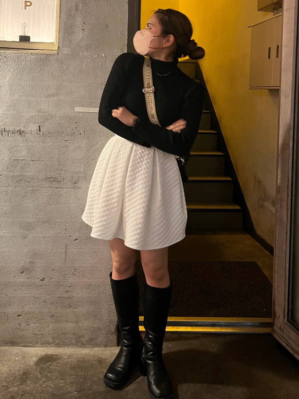 ブラック系のニット/セーター、ブラック系のバッグ、ブラック系のブーツを着用したレディースの冬コーディネートの2枚目の写真