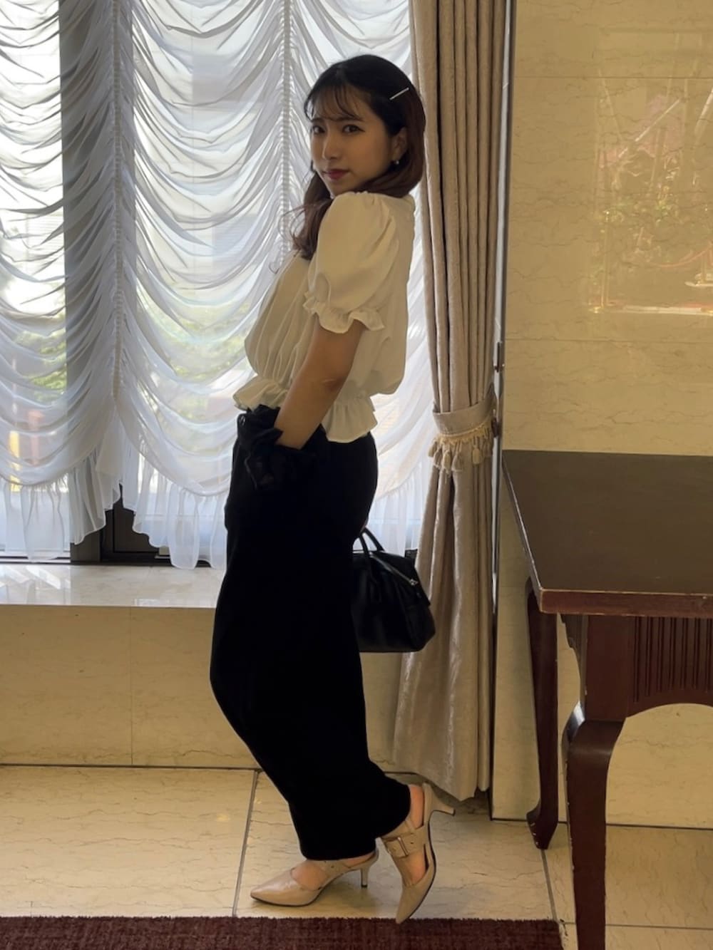 ホワイト系のシャツ/ブラウス、ブラック系のショルダーバッグ、ベージュ系のパンプスを着用したレディースの夏コーディネートの2枚目の写真