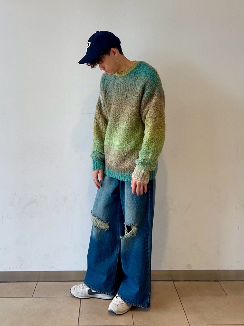 グリーン系のニット/セーター、ブルー系のデニムパンツ、ブルー系のキャップを着用したメンズの冬コーディネートの3枚目の写真