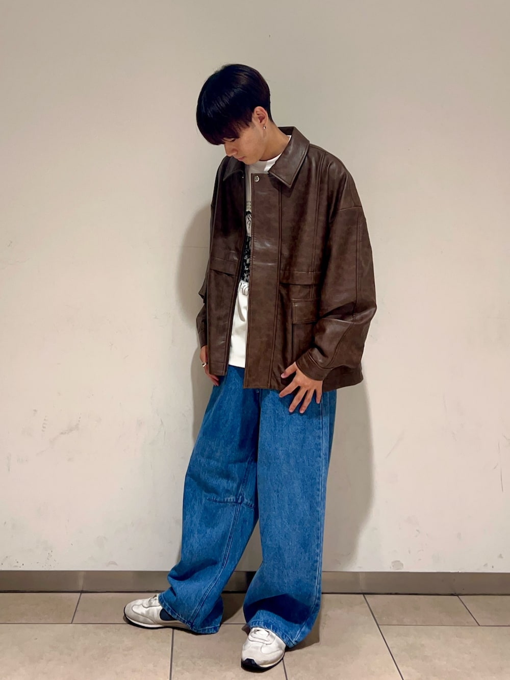 ブラウン系のその他アウター、ホワイト系のTシャツ/カットソー、ブルー系のデニムパンツを着用したメンズの秋コーディネートの2枚目の写真