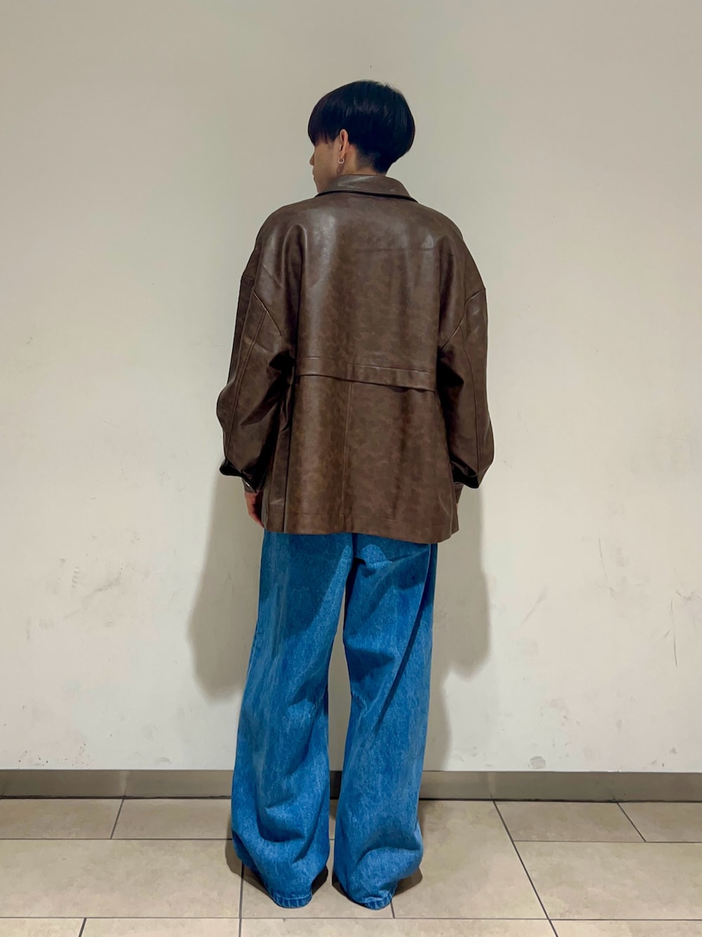 ブラウン系のその他アウター、ホワイト系のTシャツ/カットソー、ブルー系のデニムパンツを着用したメンズの秋コーディネートの3枚目の写真