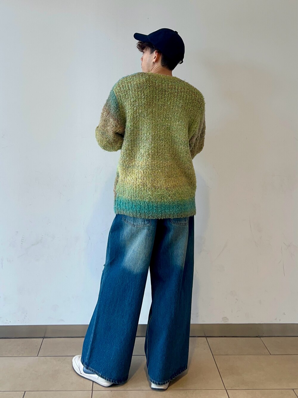 グリーン系のニット/セーター、ブルー系のデニムパンツ、ブルー系のキャップを着用したメンズの冬コーディネートの4枚目の写真