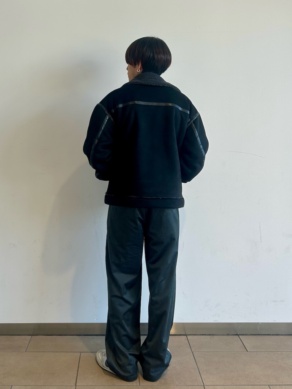 ブラック系のブルゾン、ホワイト系のニット/セーター、グレー系のその他パンツを着用したメンズの秋コーディネートの3枚目の写真