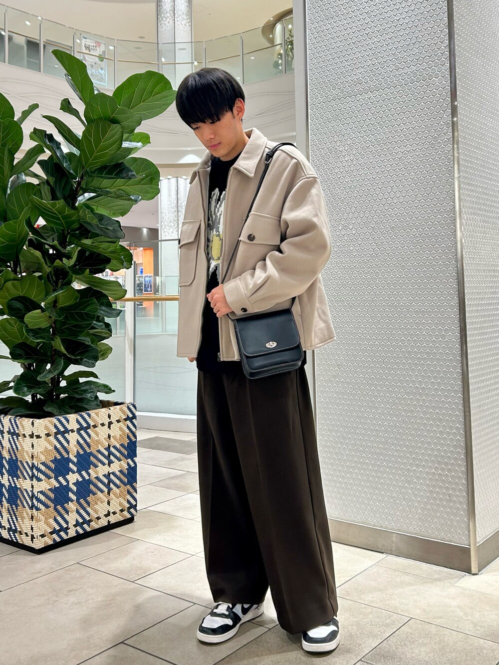 ベージュ系のブルゾン、ブラック系のニット/セーター、ブラウン系のその他パンツを着用したメンズの春コーディネートの2枚目の写真