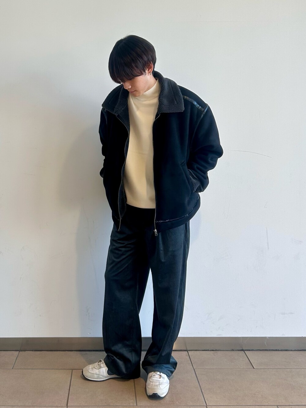 ブラック系のブルゾン、ホワイト系のニット/セーター、グレー系のその他パンツを着用したメンズの秋コーディネートの2枚目の写真