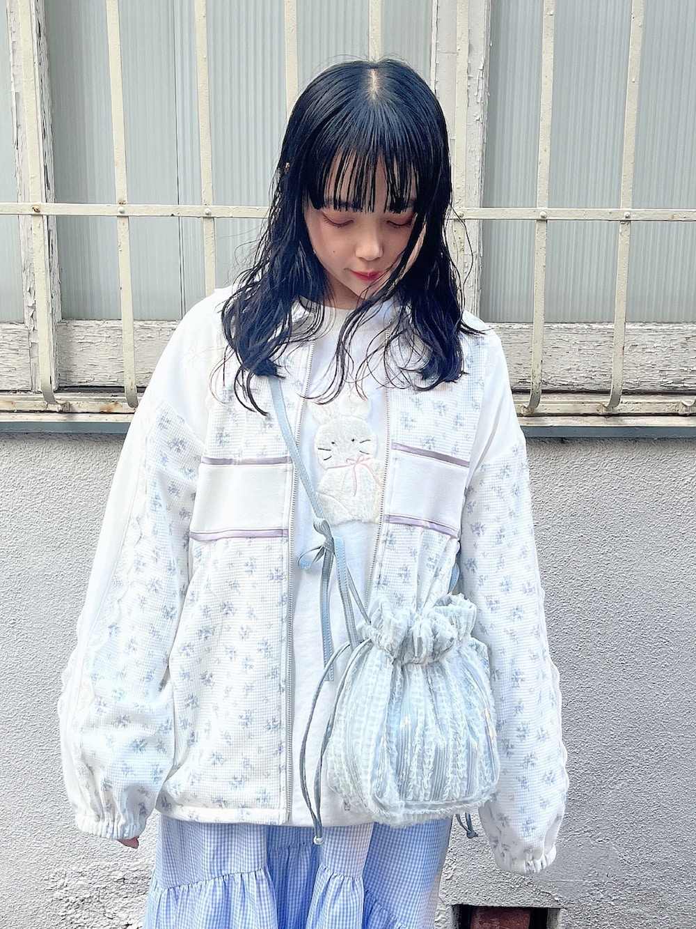 ホワイト系のスウェット、ブルー系のジャージ、ブルー系のショルダーバッグを着用したレディースの春コーディネートの7枚目の写真