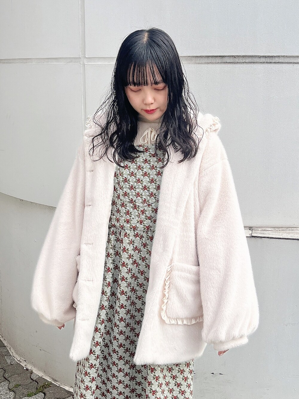 ホワイト系のニット/セーター、ホワイト系のダウンジャケット/コート、グリーン系のジャンパースカートを着用したレディースの冬コーディネートの5枚目の写真