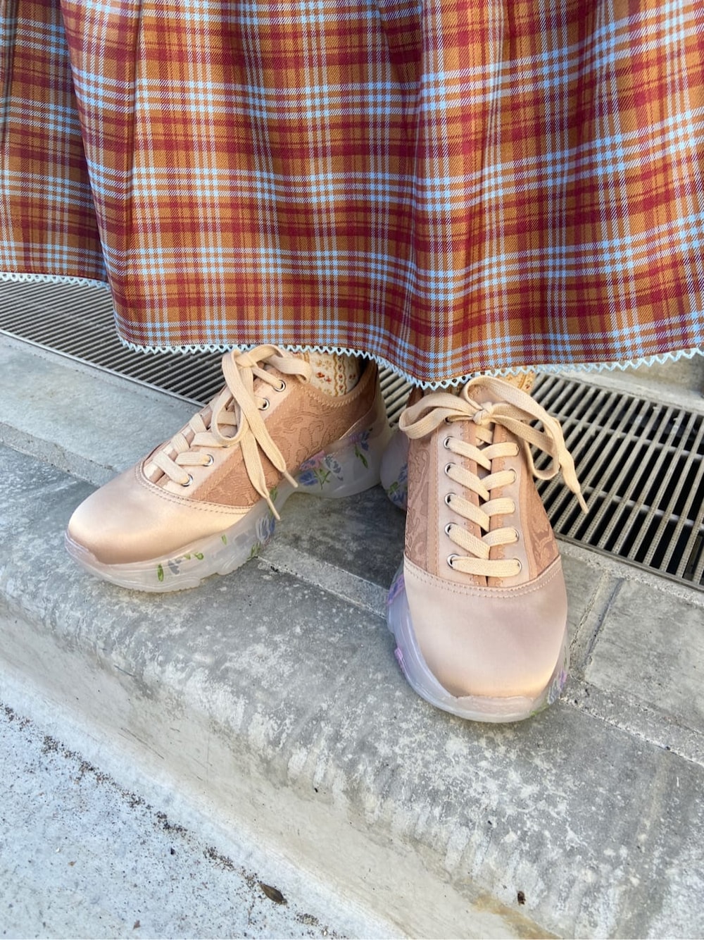 オレンジ系のスカート、オレンジ系のスニーカー、ホワイト系のニット/セーターを着用したレディースの秋コーディネートの6枚目の写真