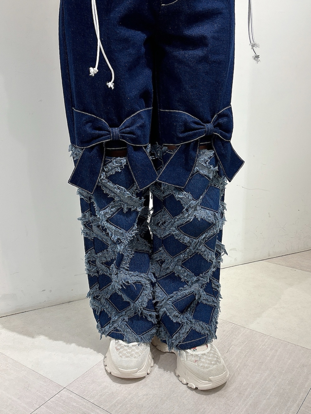 ホワイト系のジャージ、ブルー系のデニムパンツ、ホワイト系のスニーカーを着用したレディースの秋コーディネートの9枚目の写真