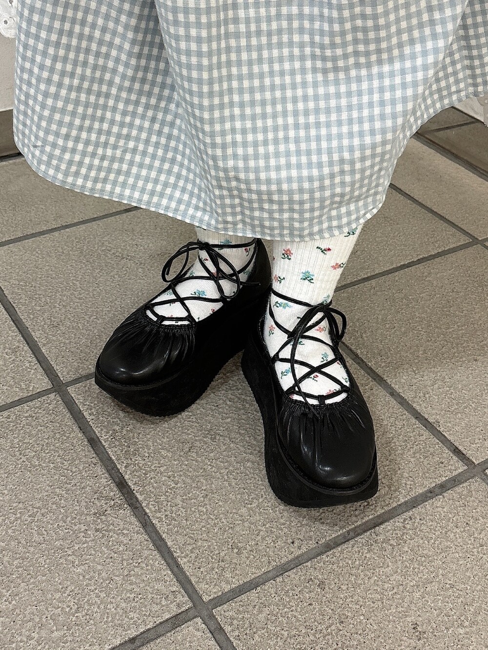 ブルー系のワンピース、ホワイト系のトレンチコート、ブラック系のバレエシューズを着用したレディースの春コーディネートの9枚目の写真