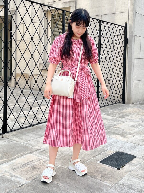 ホワイト系のショルダーバッグ、ホワイト系のサンダル、レッド系のワンピースを着用したレディースの夏コーディネートの2枚目の写真
